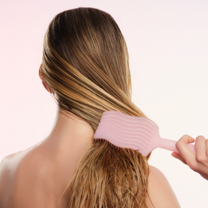 model using pink wet brush on wet hair