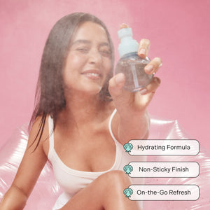 Smiling woman holding Such a Gem Kit featuring Sea Sweet Hair and Body Mist and two shell clips against a pink backdrop.