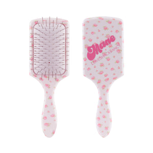 Two views of a paddle hairbrush with a white body decorated with pink strawberry patterns. One view shows the bristle underside with metal pins, and the other shows the back with the brand name 'Mare' and 'LEVENSHACKS' in pink script.