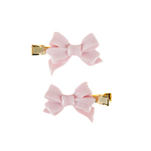 Two small pink bow hair clips with gold-tone metal clasps, shown on a plain white background.
