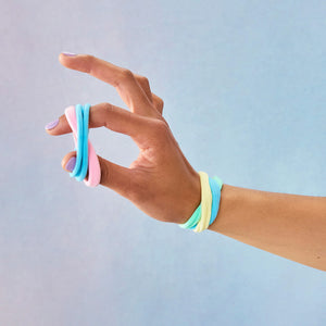 Model wearing Rainbow Fabric Hair Ties on wrist and fingers