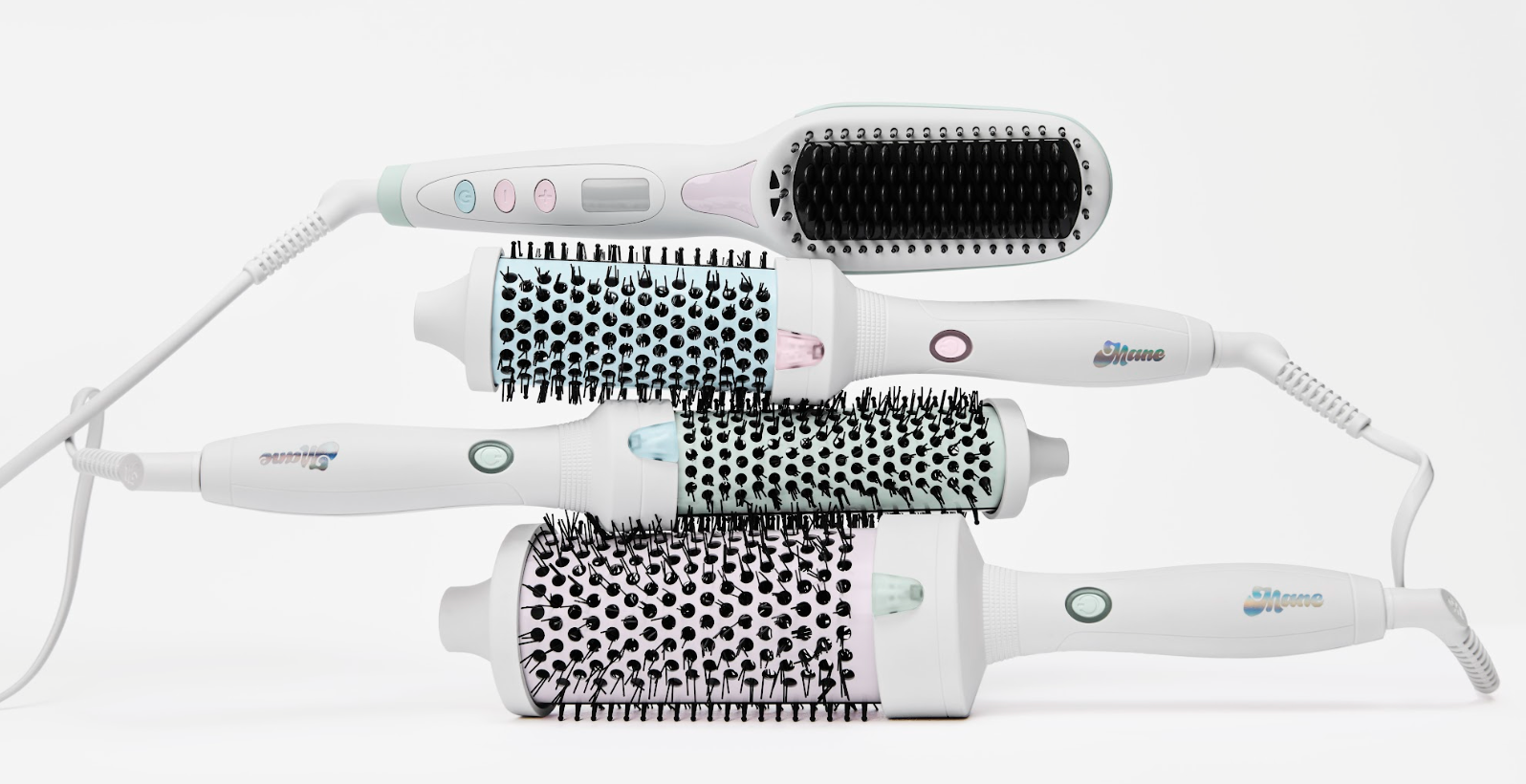 Group of white hair styling tools stacked together including brushes and a curling iron