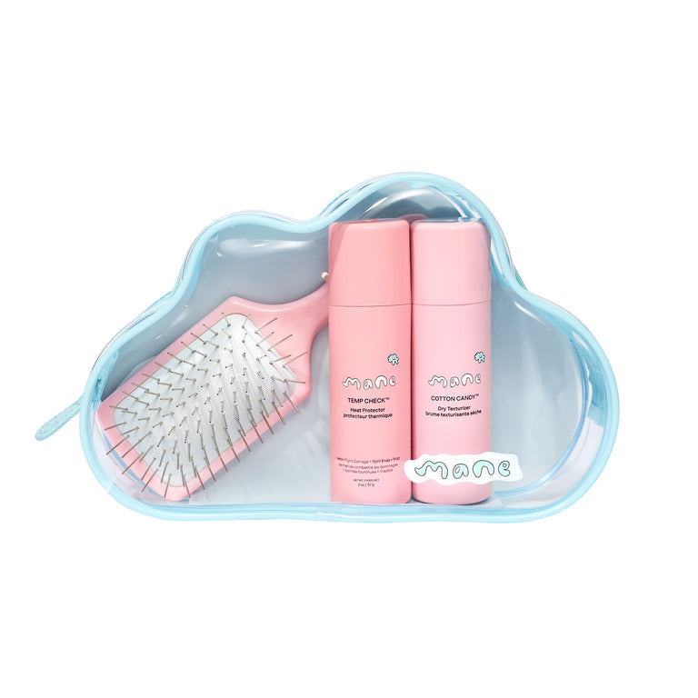 Set of hair care products including a brush and bottles in a cloud-shaped bag on a white background.