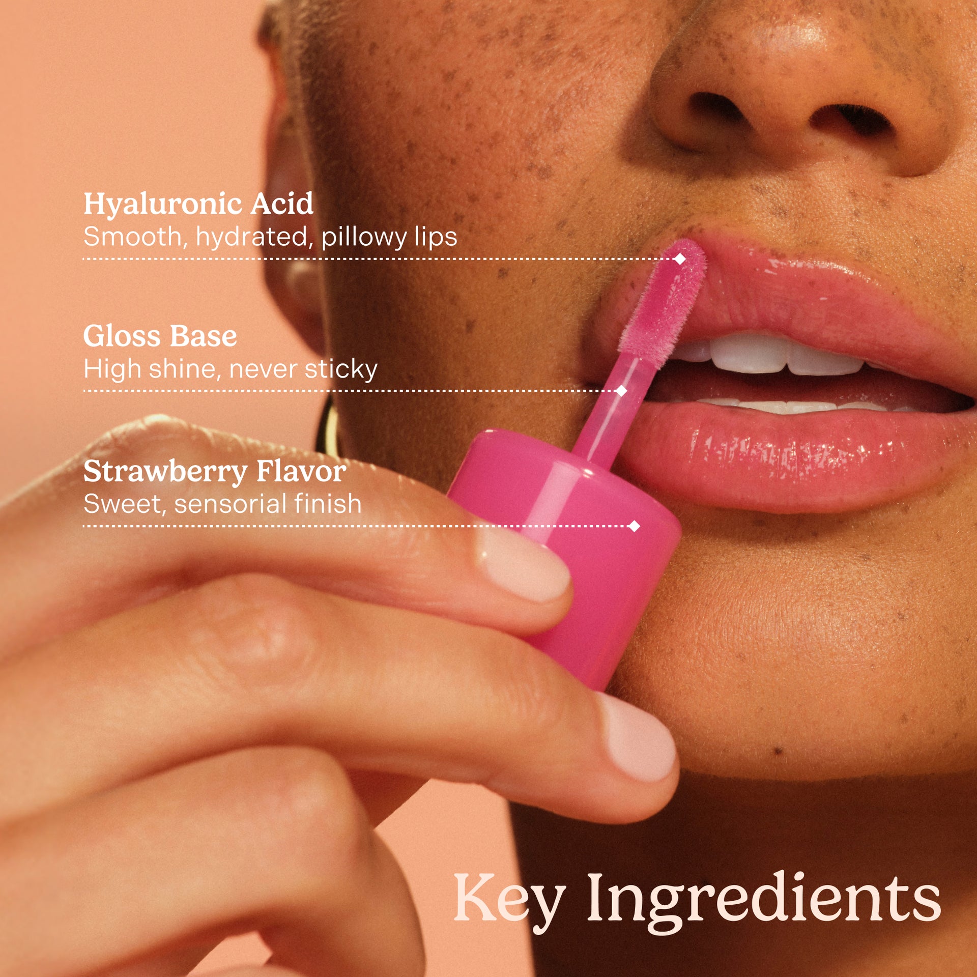 Lip balm being applied to lips with text highlighting key ingredients on a peach background