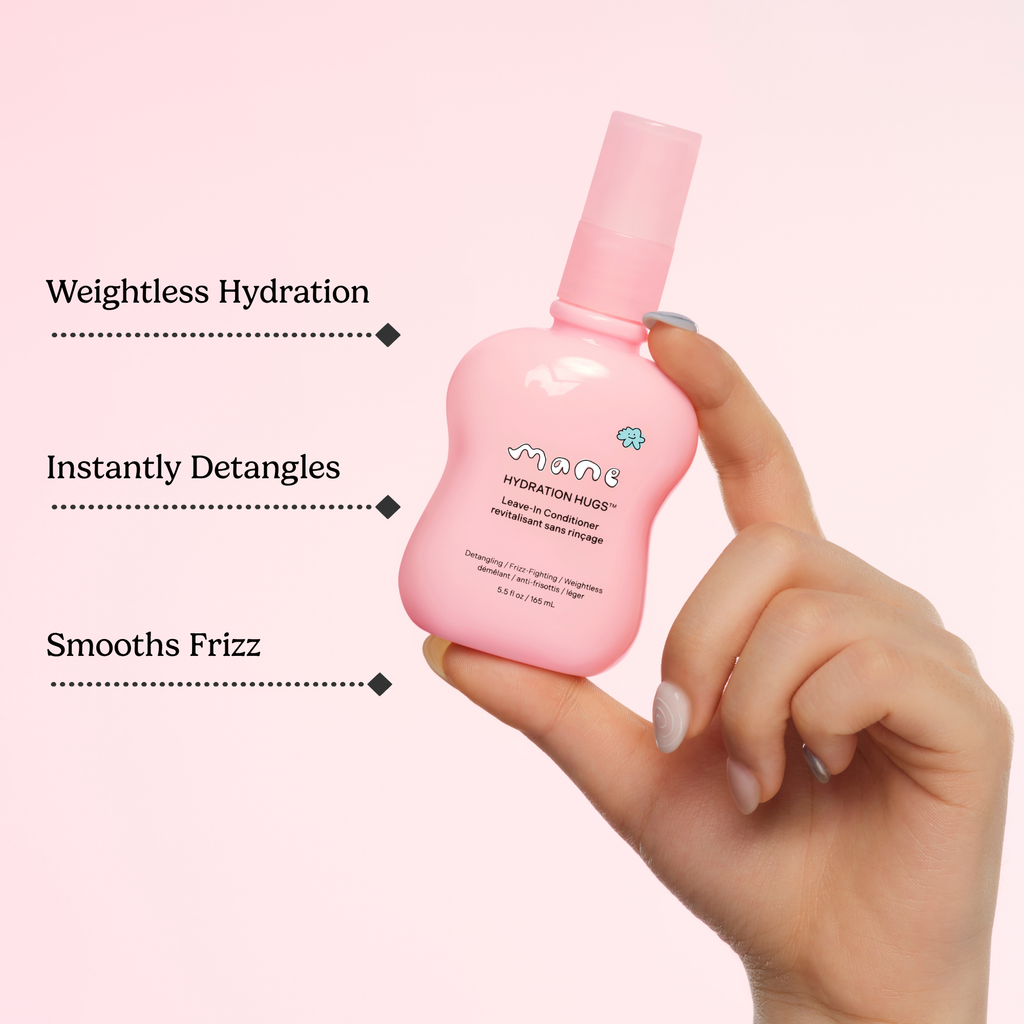 Hand holding a pink bottle of hair product with text highlighting its benefits on a light pink background