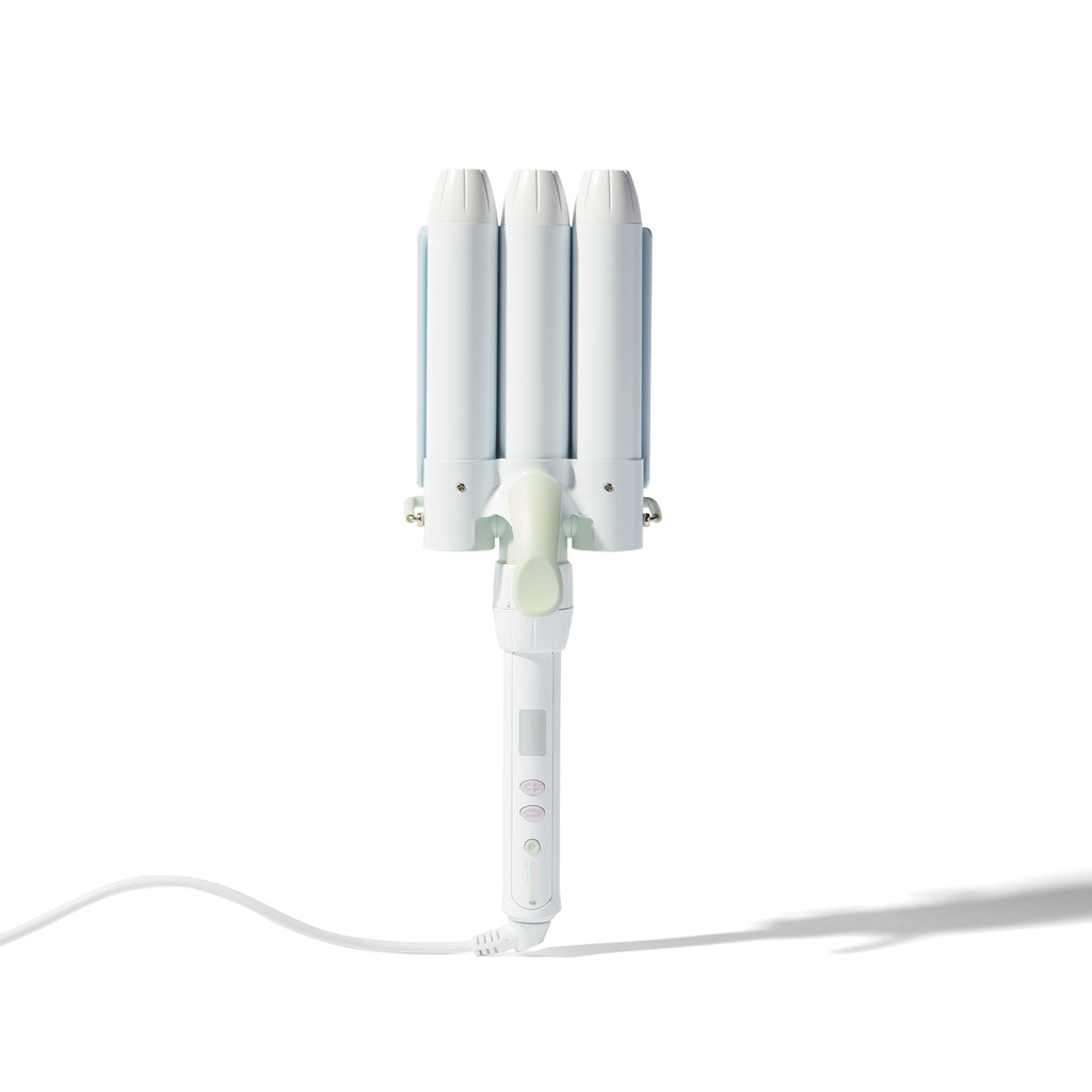 A white triple-cylinder curling iron with three curved barrels, a light green center button, and a white power cord, shown on a clean white background with a soft shadow.