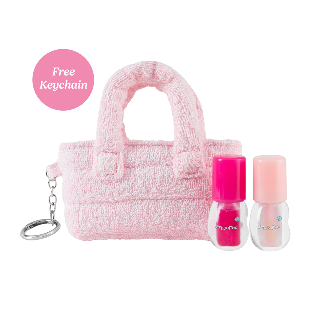 Pink fuzzy handbag with two nail polishes and a keychain on a white background