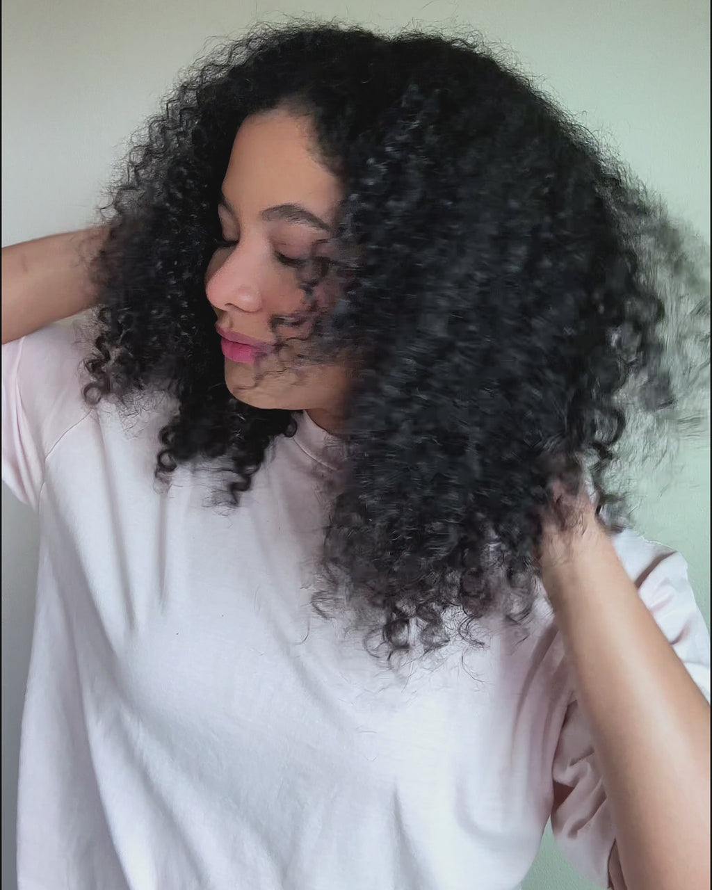 video of woman using temp check heat protector on curly dark hair and then styling it with the medium hot round brush from Mane. 
