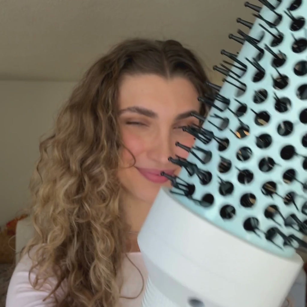 video of woman using hot round brush